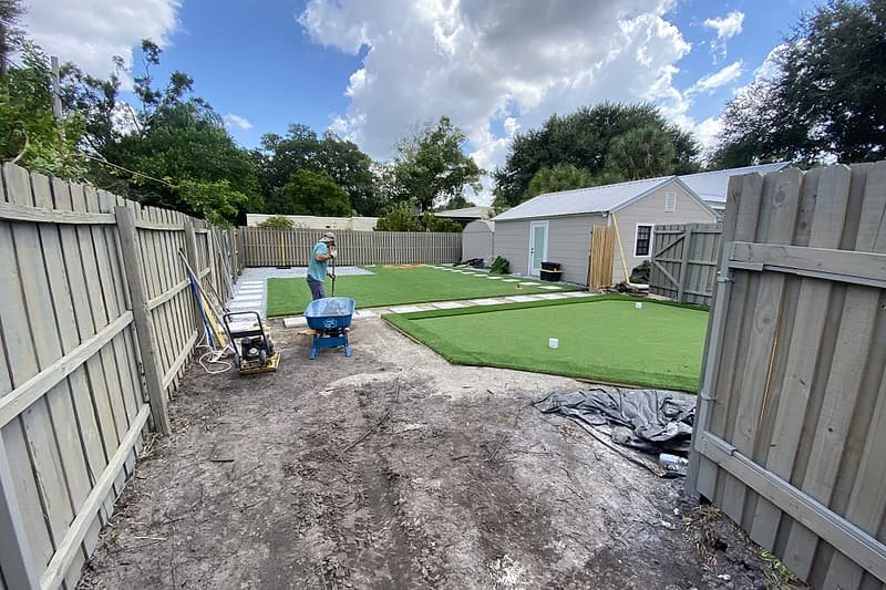 Backyard during excavation, bare soil between the fence and shed