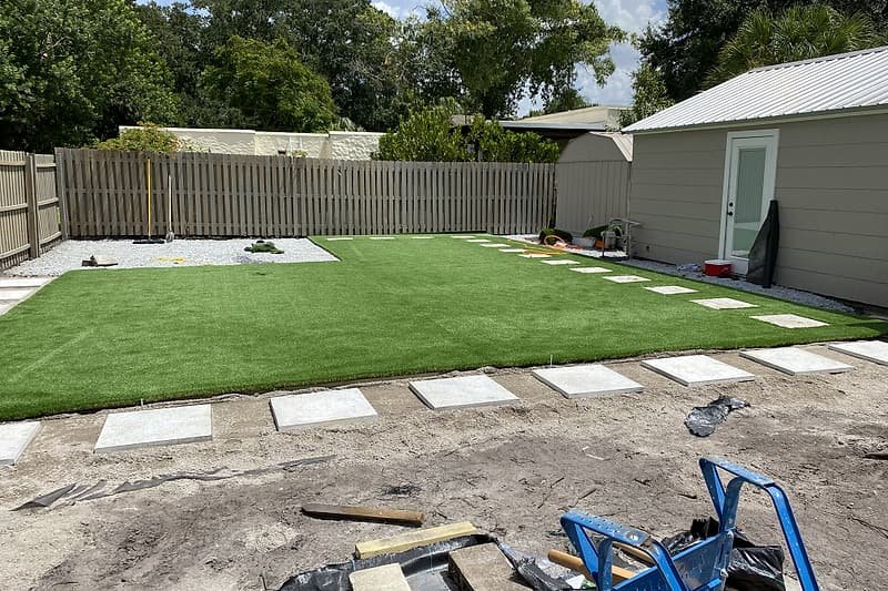 Turf and stepping pavers going down in the same backyard
