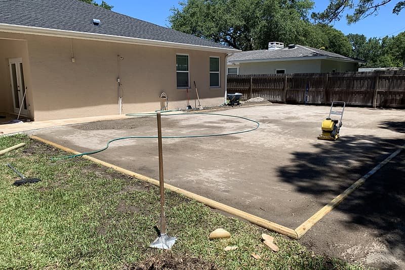 The same backyard during base preparation, graded and compacted with forms in place