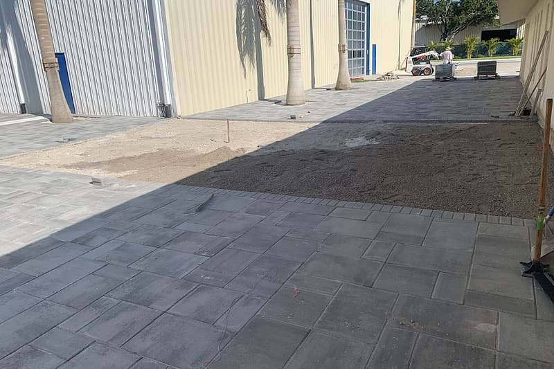 Freshly installed large-format pavers beside a commercial building